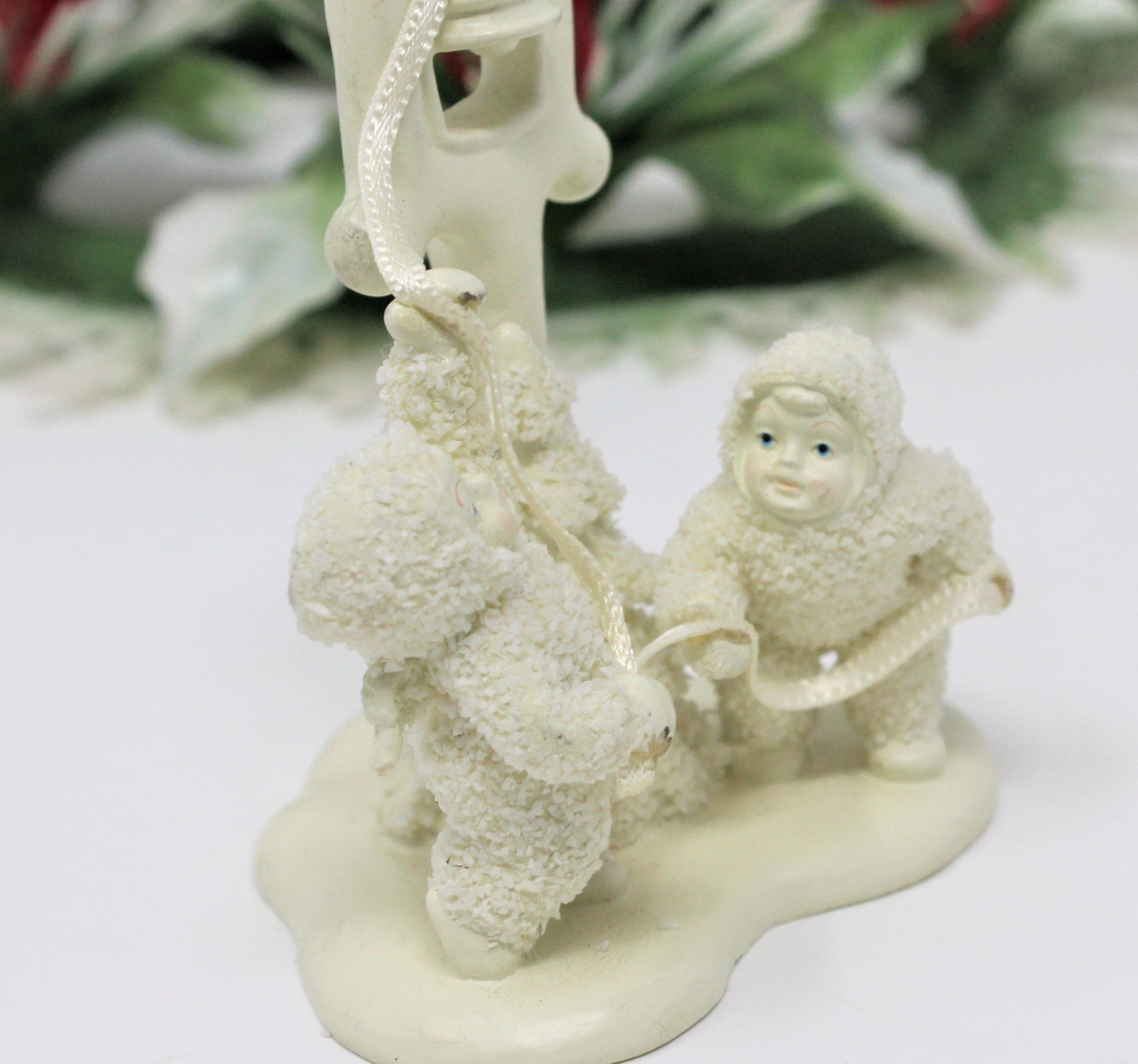 Cute image of Snow Baby feeding a good seal with a bottle. Antique not a Dept 56 rep